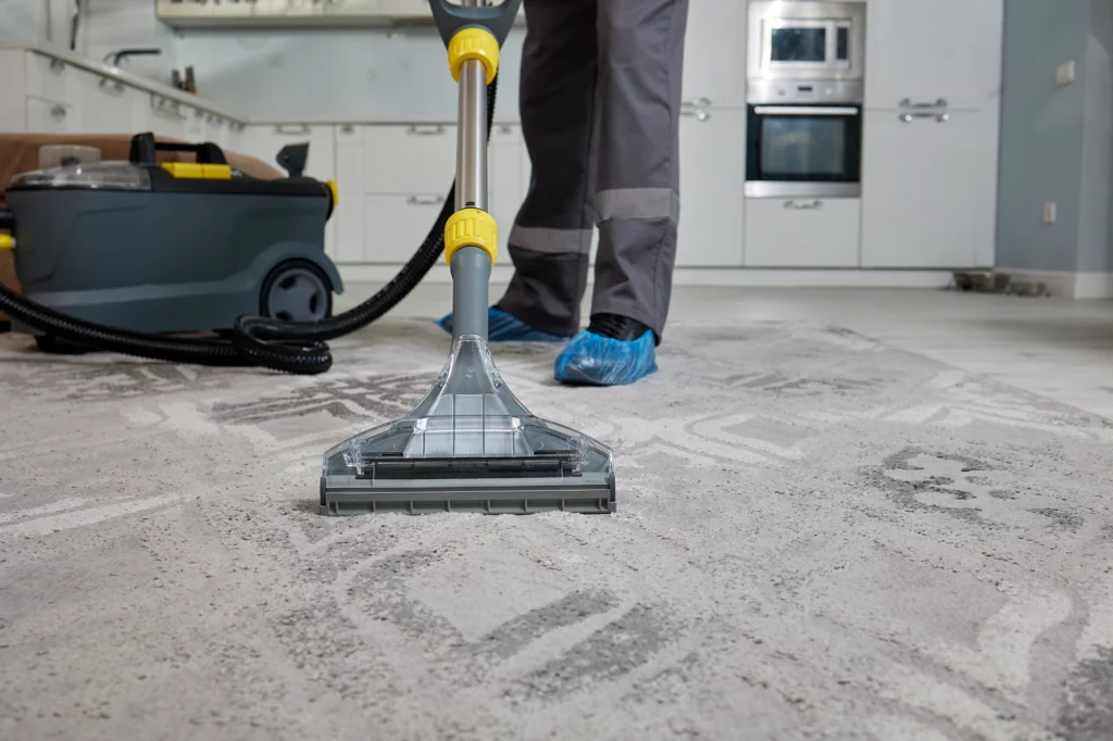 Reinigungskraft entfernt staub und Dreck nach einer Renovation